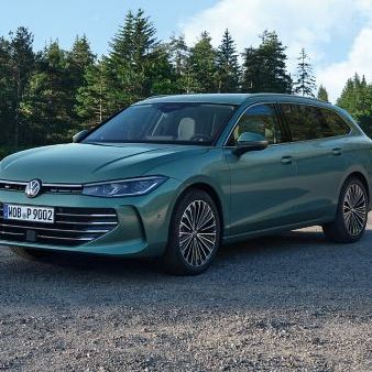 VW Der neue Passat VW Passat in blaugrün steht auf einer Kiesfläche, das Gelände grenzt an einen Tannenwald.